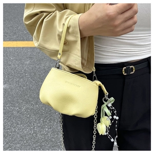 Détail du sac seau en cuir grainé jaune pâle avec chaîne argentée et breloque tulipe