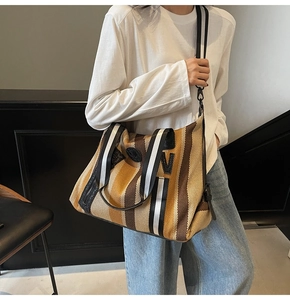 Detailed view of the striped canvas yoga tote bag on model showing large capacity and strap