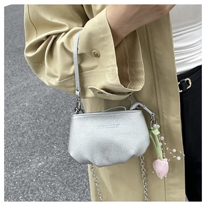 Détail du sac seau en cuir argenté avec bandoulière chaîne et breloque tulipe perle