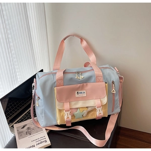 Dettaglio della borsa da viaggio in nylon multicolore con doppi manici e tracolla rosa