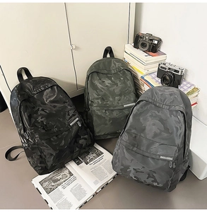 Detailed view of camo print nylon backpacks in black, olive green, and smoke grey