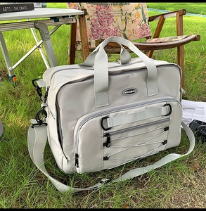 Detail of grey large capacity travel bag with front pocket and durable handle