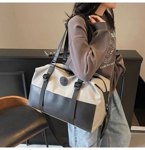 Detail of the large capacity crossbody travel bag with two-tone design and shoulder strap