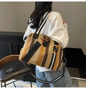 Detail showing the large capacity and striped canvas texture of the tote gym bag