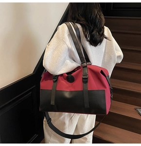 Red crossbody travel bag with black accents shown on stairs for fitness and travel