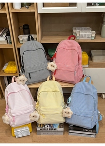 Gros plan de sacs à dos à carreaux colorés avec pendentifs en peluche en forme d'étoile
