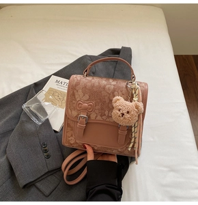 Detailed view of a vintage floral patchwork handbag with teddy charm and silk scarf