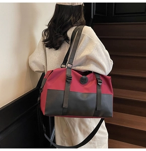 Detail of burgundy and black gym bag showing large capacity and detachable shoulder strap