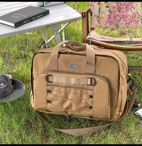 Detail of khaki outdoor travel bag featuring MOLE webbing system and elastic cord