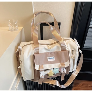 Vista dettagliata della borsa da viaggio beige sulla valigia con la tasca a stella trasparente