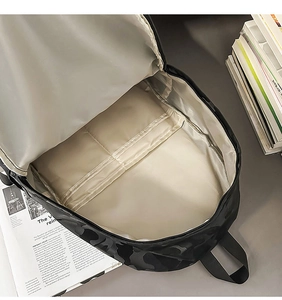 Detailed top view of black camo backpack interior with laptop sleeves and beige lining