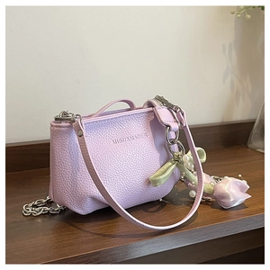Détail du sac lilas en cuir grainé avec charm tulipe et perles sur le côté de l'anse