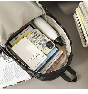 Top view of camouflage backpack interior showing storage space for a tablet and books