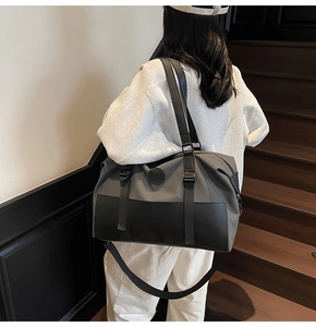 Detailed view of the grey large travel bag with adjustable strap and embossed logo