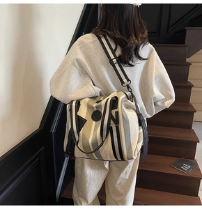 Outdoor model wearing a striped canvas tote bag with adjustable shoulder strap