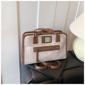 Detail view of retro gray and brown briefcase with metal logo and textured finish