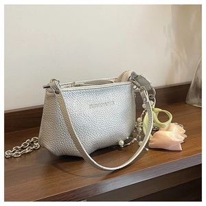 Sac seau en cuir argenté avec chaîne en métal et charms floraux en gros plan