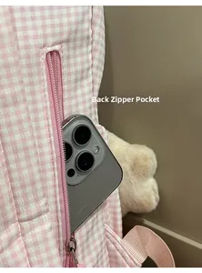 Vue détaillée de la poche arrière zippée du sac à dos à carreaux roses pour téléphone