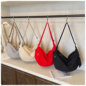 Detail of multi-color crescent crossbody bags with adjustable straps in a row