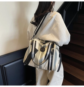 Detailed shot of large striped canvas tote bag with adjustable black shoulder strap