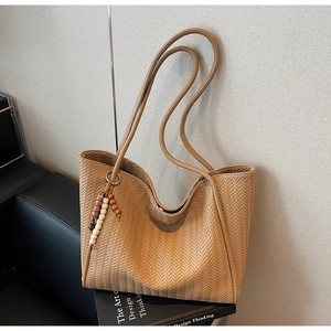 Detailed wave weave texture and boho beaded tassel on a khaki large tote bag