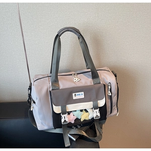Dettaglio della borsa da viaggio in nylon grigio-viola con tasche e ciondolo a stella
