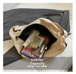 Spacious interior of beige nylon crossbody bag showing tablet and cosmetic storage