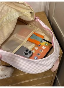 Détail de l'intérieur du sac à dos à carreaux roses avec poches filet et compartiments triés