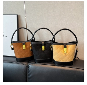 Trois sacs seaux matelassés en marron, noir et beige avec fermoirs métalliques dorés