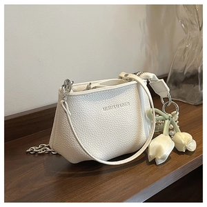 Détails du sac seau blanc en cuir litchi avec chaîne argentée et breloque en perle