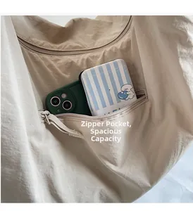 Detail of canvas tote bag featuring an internal zipper pocket with phone and card holder