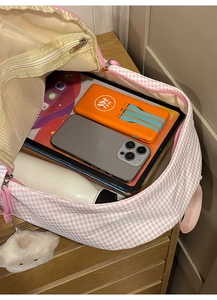 Vue détaillée de l'intérieur spacieux du sac à dos à carreaux rose avec iPad et gourde