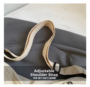 Detail view of the adjustable nylon shoulder strap with a black plastic buckle on a bag