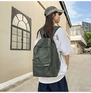 Outdoor street view of dark green camouflage backpack with waterproof large zipper pocket