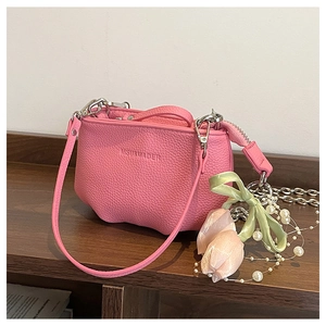 Détail du sac à main en cuir grainé rose avec chaîne argentée et fermeture éclair