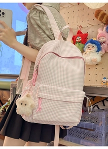 Vue détaillée du sac à dos à carreaux rose avec étoile en peluche sur le dos