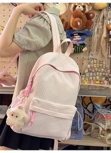 Vue latérale détaillée du sac à dos à carreaux roses avec breloque étoile et poche avant