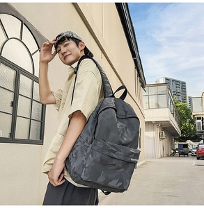 Detail shot of waterproof dark camouflage backpack showing texture and padded straps