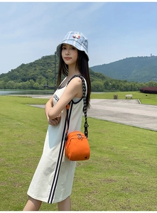 Foto lifestyle de un bolso bandolera de nailon naranja brillante con compartimentos
