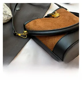 Gros plan sur un sac matelassé marron avec cuir noir et fermoir métallique doré