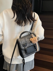 Retro floral backpack in black and gray with adjustable straps and a plush bear charm
