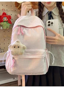 Gros plan du sac à dos à carreaux roses avec tissu durable et breloque étoile jaune