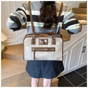 Detail view of large grey lace bow tote bag with brown straps and metal zipper pocket