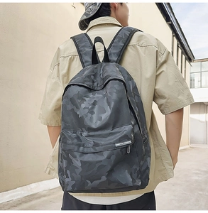 Outdoor shot of the black camouflage backpack with padded straps and brand label detail