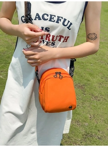 Bolso bandolera de nailon naranja brillante con cremallera doble y detalle de logotipo