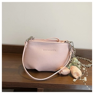 Détail du sac seau en cuir grainé rose avec chaîne argentée et ornements de perles