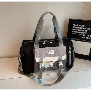Dettaglio della borsa da viaggio con finestra trasparente e decoro con pompon colorati
