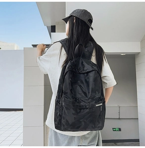 Detail of black camo backpack showing multi-pocket design and water-resistant fabric