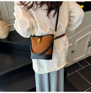 Détail du sac seau en daim matelassé marron avec finitions cuir noir et fermoir doré