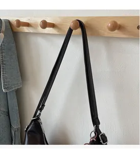 Dettaglio di una borsa tote vintage in pelle nera con cerniera argento e tracolla